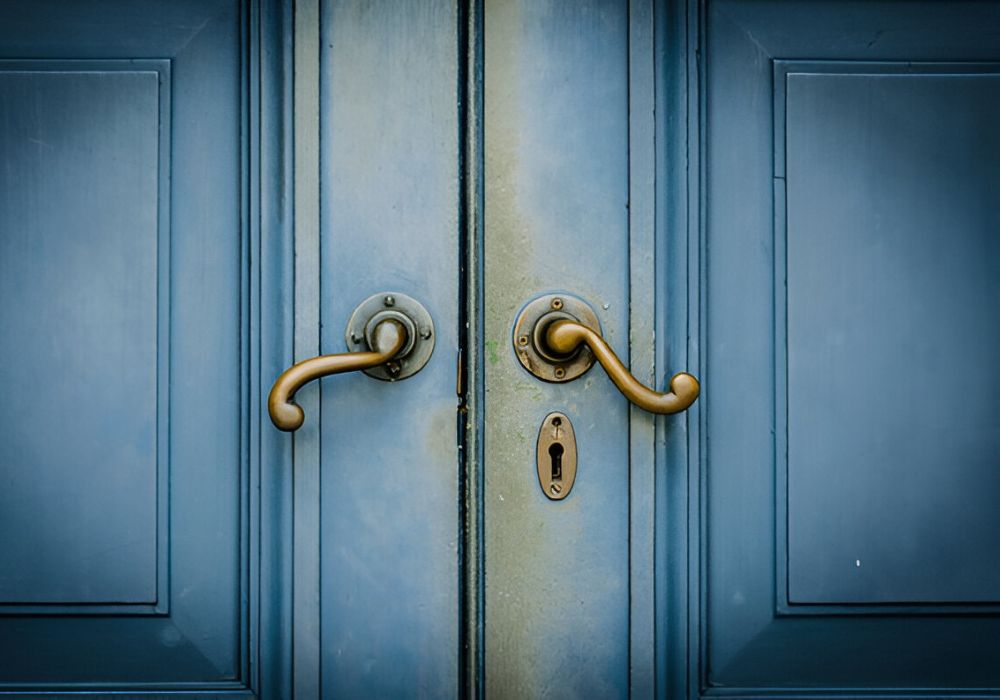 Blauwe voordeur met klassiek sleutelgat en handgrepen