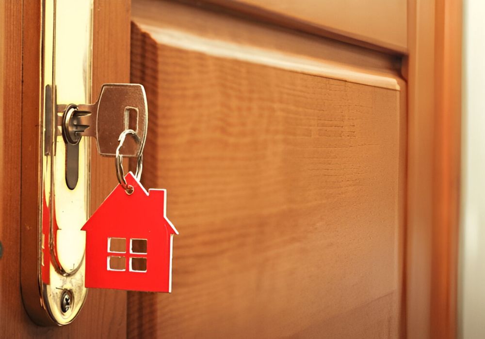 Sleutel in voordeur met huisvorm hanger